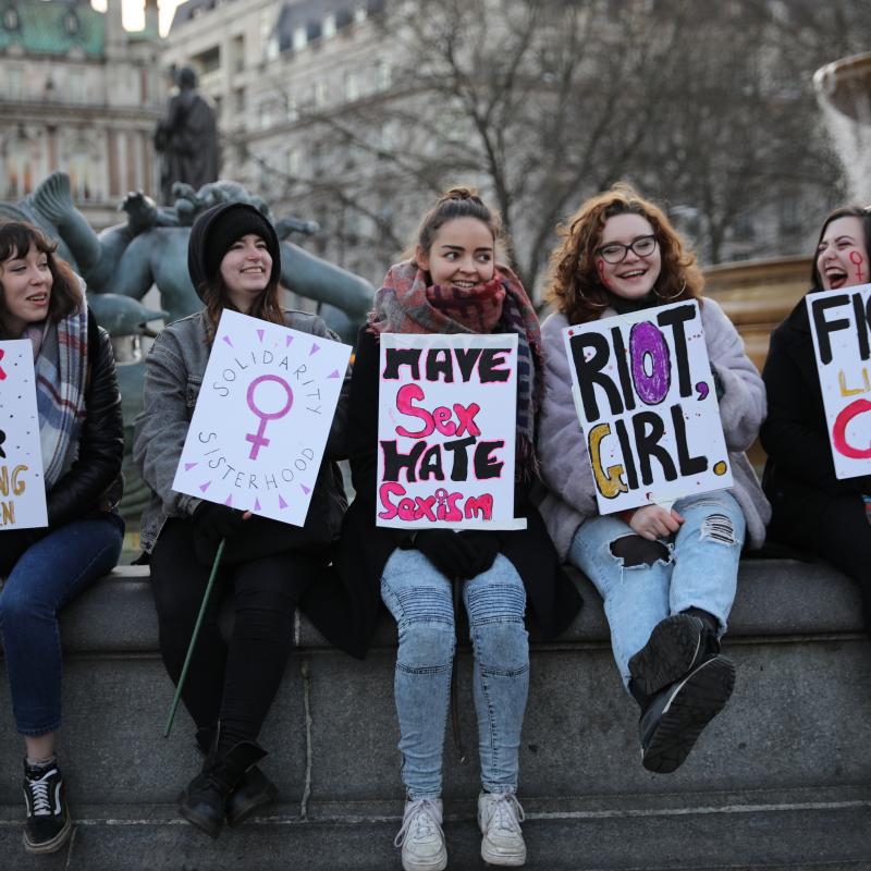 A group of young feminist girls holding protest signs at a demonstration