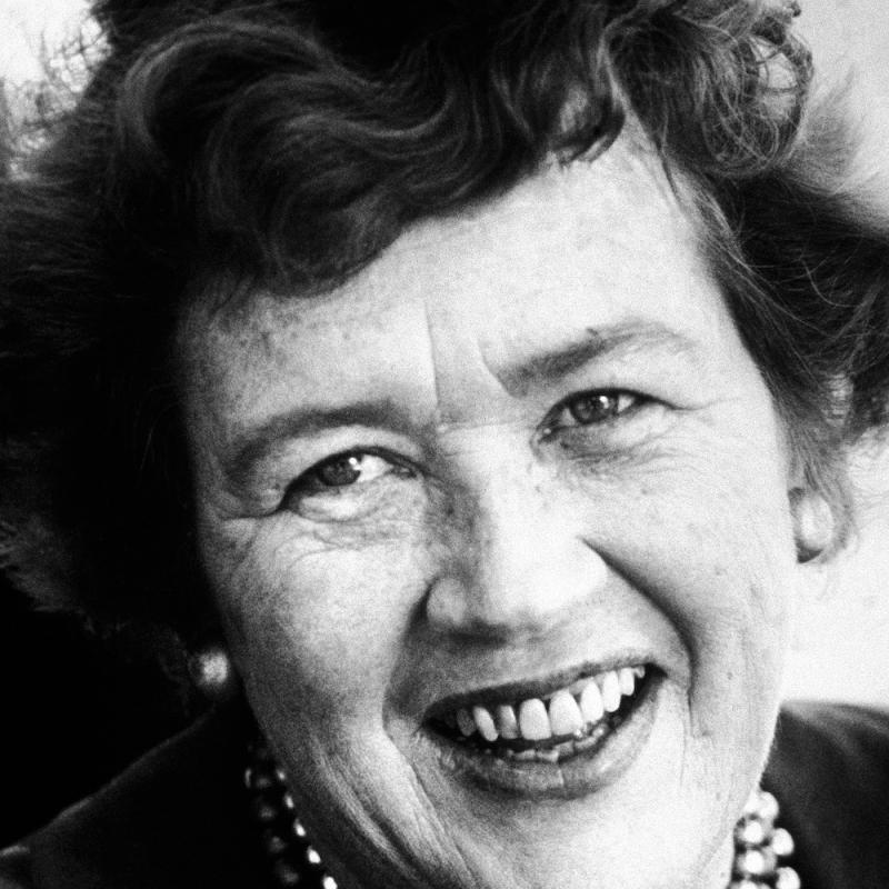 Portrait of chef and author Julia Child smiling in an old black and white photo