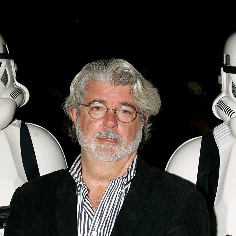 Film director George Lucas stands next to two Stormtroopers from his movie Star Wars
