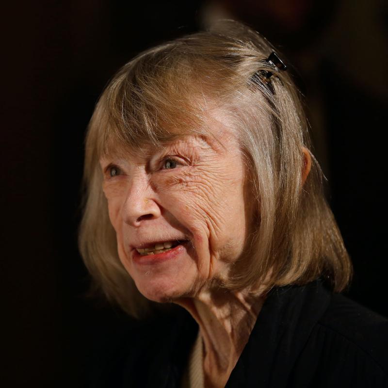 Writer Joan Didion against a black backdrop in 2012