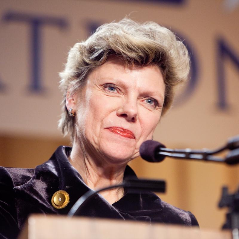 News anchor Cokie Roberts speaks into a microphone at a lectern