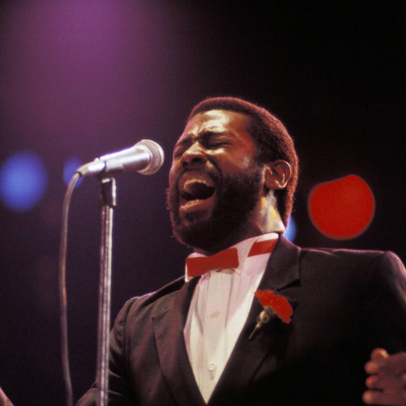 R&B singer Teddy Pendergrass sings into a microphone